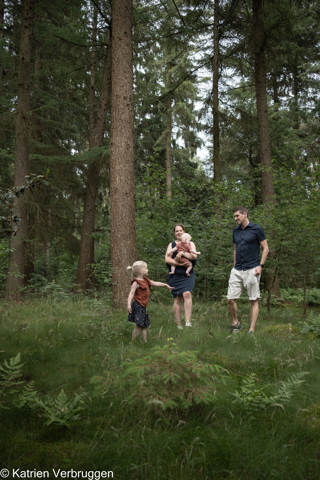 Gezin wandelt tussen de dennenbomen