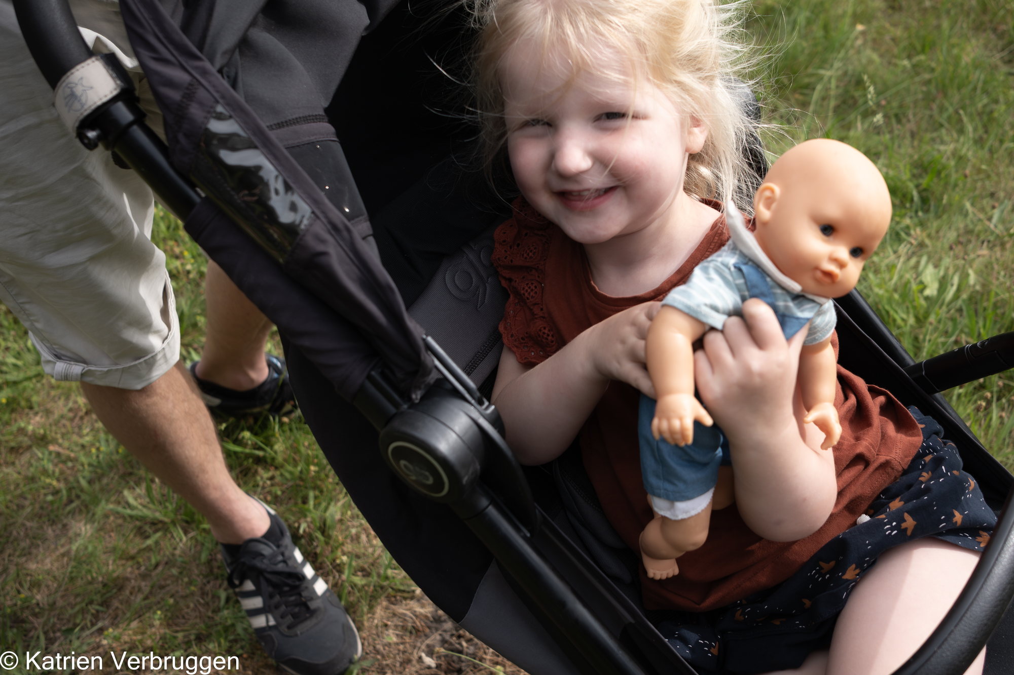 Meisje met haar pop in de buggy