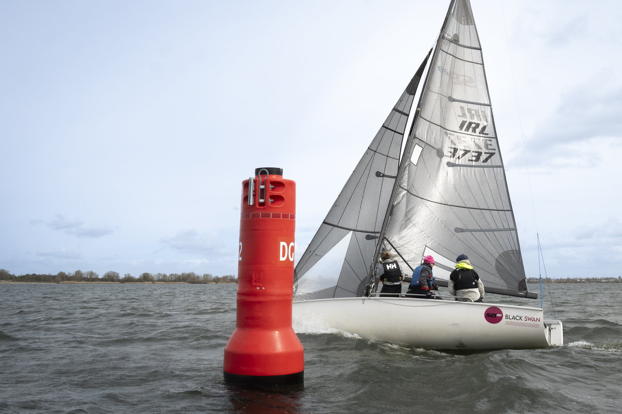Boei en zeilboot op het ruime water