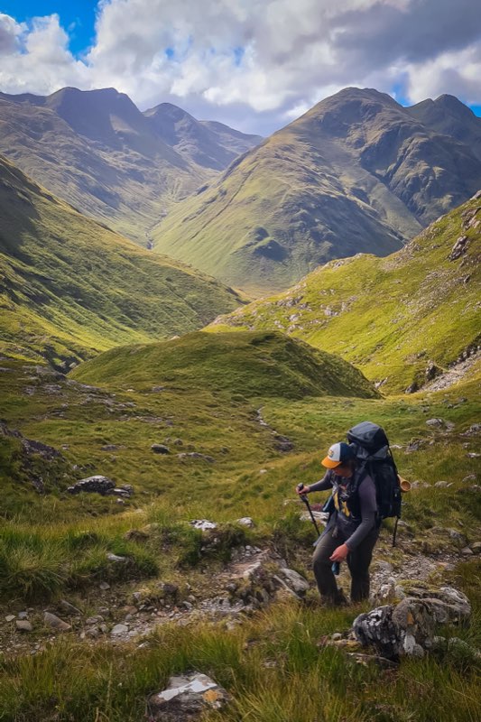 Met de trekkingrugzak door een groene bergvallei